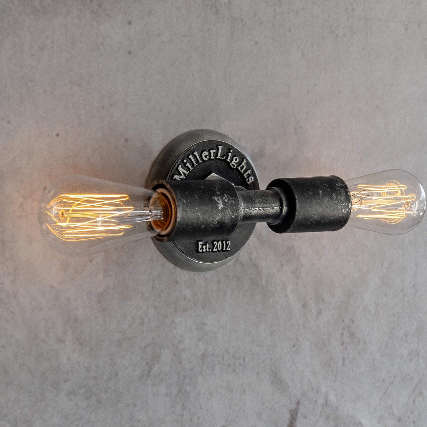 Minimalist Industrial Exposed  two Edison-style light bulbs on a concrete wall 